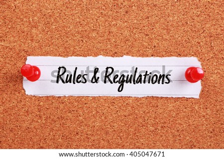 Text Rules And Regulations written on note paper pinned on the corkboard.