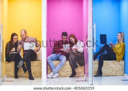 group of young business people having fun, relaxing and working in creative room space at modern startup office Royalty-Free Stock Photo #405063319