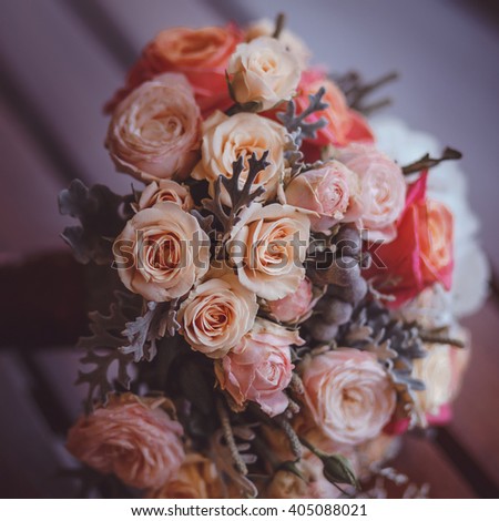 Wedding bouquet of various flowers on wooden table in cafe