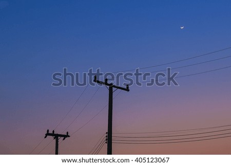 the silhouette electricity post in the twilight time with the moon