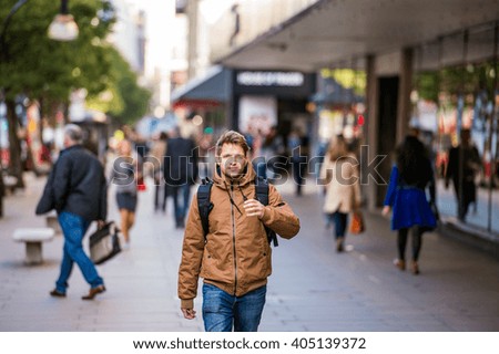 Hipster man walking in the streets of London Royalty-Free Stock Photo #405139372
