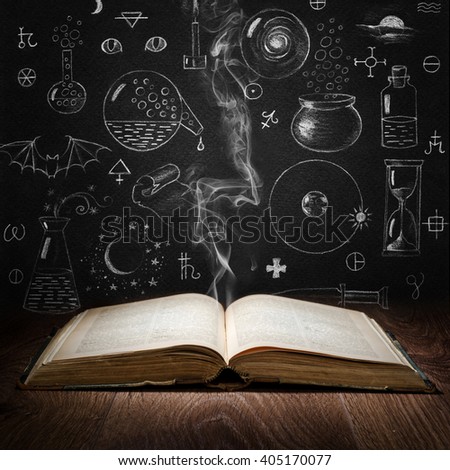 Opened magic book with alchemy symbols on chalkboard. Philosophy, spirituality, occultism, chemistry, science, alchemy and magic symbols. Royalty-Free Stock Photo #405170077