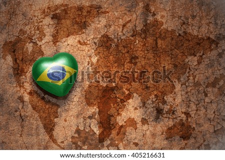 heart with national flag of brazil on a vintage world map crack paper background. concept