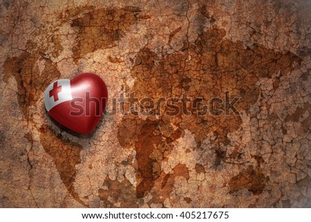 heart with national flag of Tonga on a vintage world map crack paper background. concept