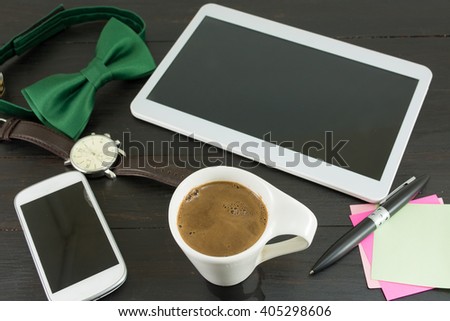 Cup of coffee for a good working day. Coffee and tech accessories on black table