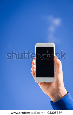 Closeup on hand taking sky photo with smart phone, blue background outdoors