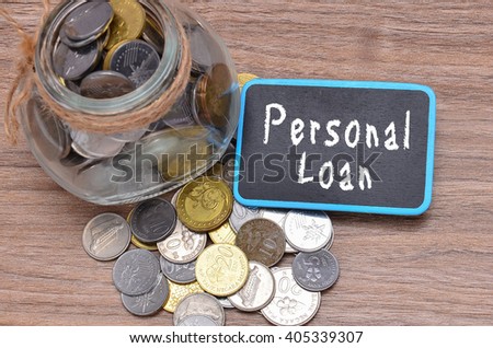 Isolated coins in jar with Personal Loan word on mini chalkboard - financial concept