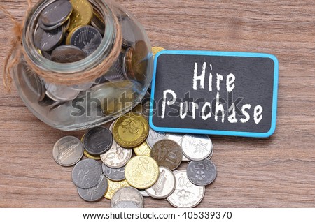 Isolated coins in jar with Hire Purchase word on mini chalkboard - financial concept Royalty-Free Stock Photo #405339370