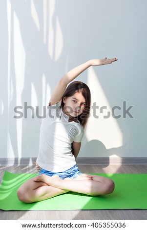 little girl doing gymnastics on a green yoga mat. children's fitness, yoga for kids. doing fitness exercise, on white background. 