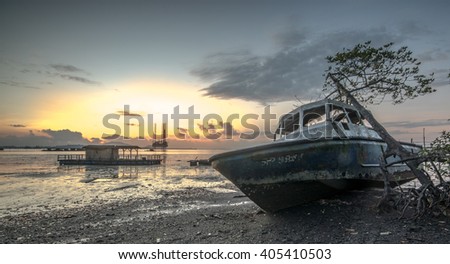 sunrise seascape with boat and foreground with rock