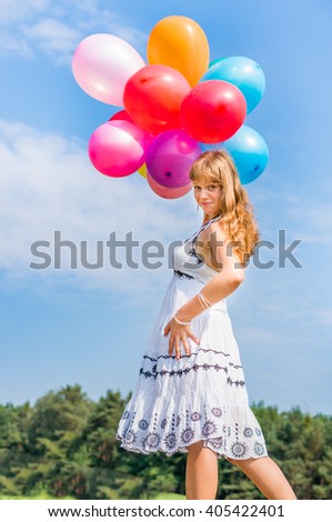 Happy young lady celebrates birthday and playing with balloons