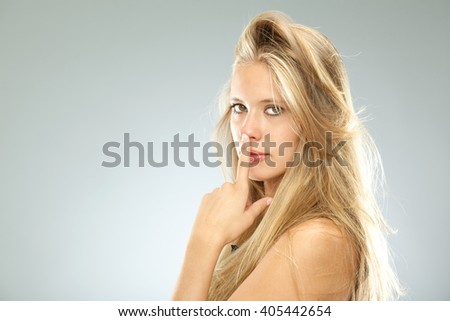 beautiful blonde serious girl black dressed isolated on grey
