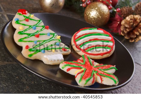 Colorful hand decorated christmas holiday cookies with christmas decorations in the background