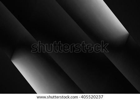 Rays of light in the darkness. Studio shot of screens diffusing light at their edges. Abstract black and white scientific, technological or architectural background composition with backlight.