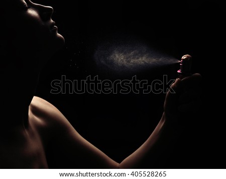 Woman's perfume in the hand on black background  Royalty-Free Stock Photo #405528265
