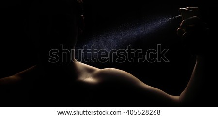 Man's perfume in the hand on black background  Royalty-Free Stock Photo #405528268