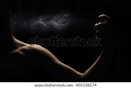Woman's perfume in the hand on black background  Royalty-Free Stock Photo #405528274