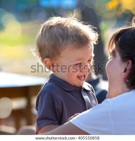beautiful blonde child play with his mum outdoor