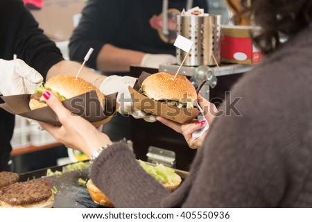 Beef burgers being served on food stall on open kitchen international food festival event of street food. Royalty-Free Stock Photo #405550936