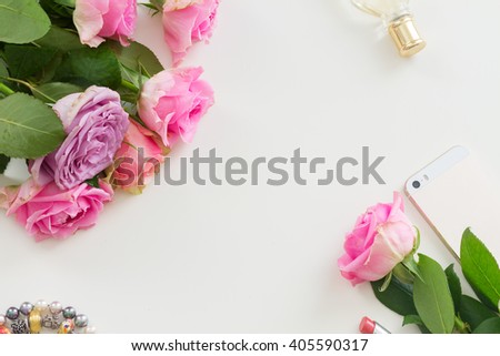 Styled desktop scene  with  mobile and flowers, copy space on white table