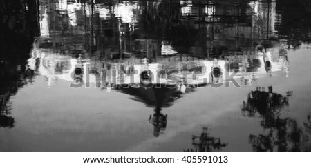 Blurred toned photo of carousel reflection in canal's water. Annecy (Haute-Savoie, France). Black and white.