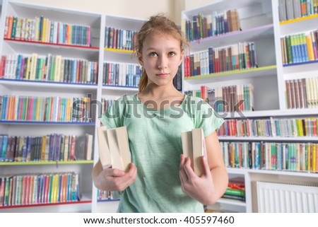 Cute girl reading book in library 


