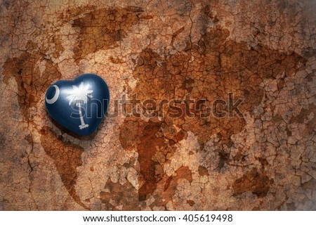 heart with south carolina state flag  on a vintage world map crack paper background. concept