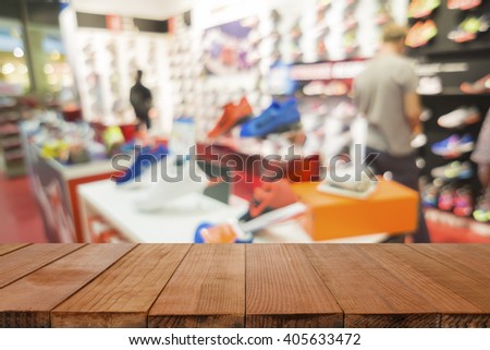 Empty brown wooden table and De focused/blurry background of Sports clothing store in Inter Sport store,with bokeh image, can be used for montage or display your products