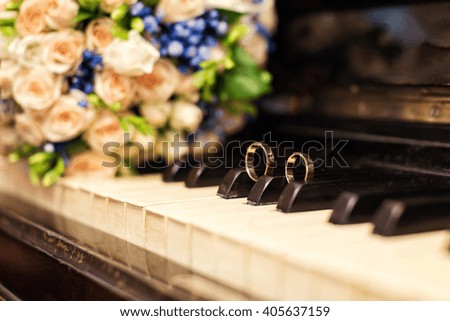 wedding rings lie on the piano keys