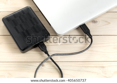 External hard drive connected to laptop computer, selective focus
