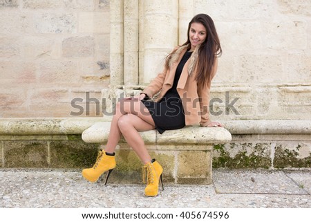 Beautiful girl sitting on a bench, brunette in a dress, fashion life style .