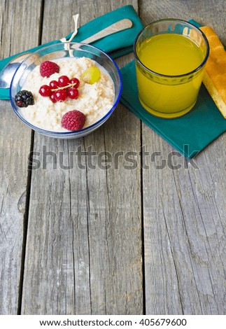 Healthy breakfast. oatmeal with berries and glass of juice, cup of coffee, cakes and toasts on table. good morning room for text. Toned image