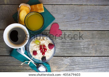 Healthy breakfast. oatmeal with berries and glass of juice, cup of coffee, cakes and toasts on table. good morning room for text. Toned image