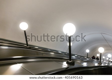 Modern escalator with lamps in Moscow underground, Russia.