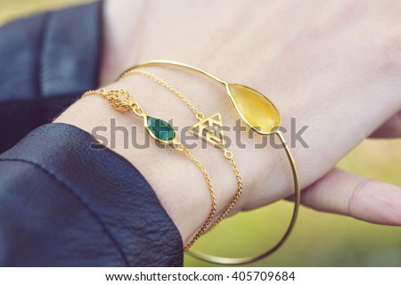 Female hand with three golden bracelets Royalty-Free Stock Photo #405709684