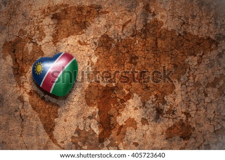 heart with national flag of namibia on a vintage world map crack paper background. concept