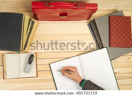 Financial concept. Businessman counting profit and losses, analyzing financial results. On a wooden table books, documents, calculator, red briefcase. Copy space. Top view.