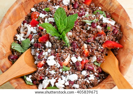 Closeup on quinoa and red beans salad on bamboo bowl, ready to be served with wooden spoon and fork Royalty-Free Stock Photo #405839671