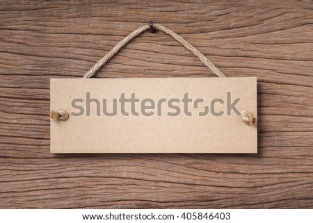 blank paper signboard hanging on old wood