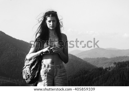 happy beautiful girl hipster traveling on top hill on background of amazing sky and mountains in summer, black and white