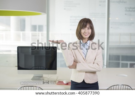 Attractive asian business woman showing something on workplace