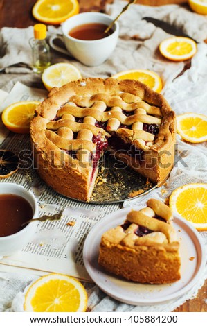 Homemade pesonen cake with cherry filling for breakfast family. Homemade cherry pie on rustic background. Rustic dark styling. Cherry  pie with cut piece on a marble background, overhead scene