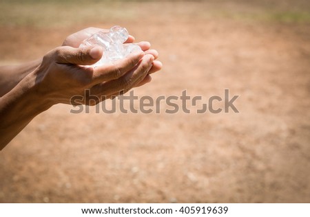 Ice in hands of a man. (selective focus)