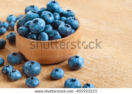 Blueberries in bowl on wooden background. Close up, top view, high resolution product. Harvest Concept