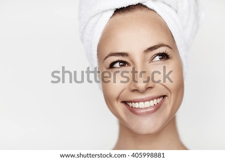 Smiling young brunette wearing towel on head