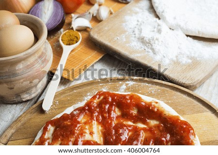 Home pizza original set, pizza dough and ingredients on wooden table, soft focus.
