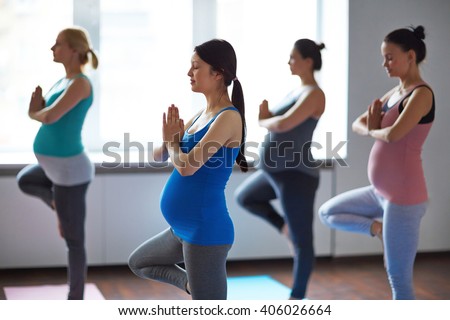 Pregnant women exercising in yoga class Royalty-Free Stock Photo #406026664