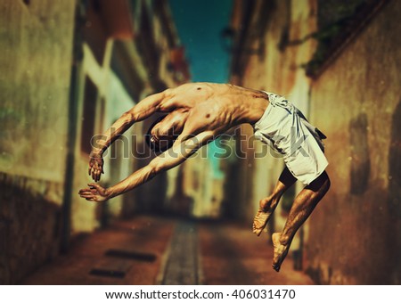 Young man dancer jumping on old town street background