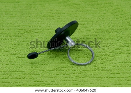 Magnetic bottle security tag on a green fabric