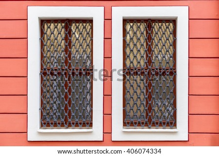A window in the tenement house on an ornamental red wall.